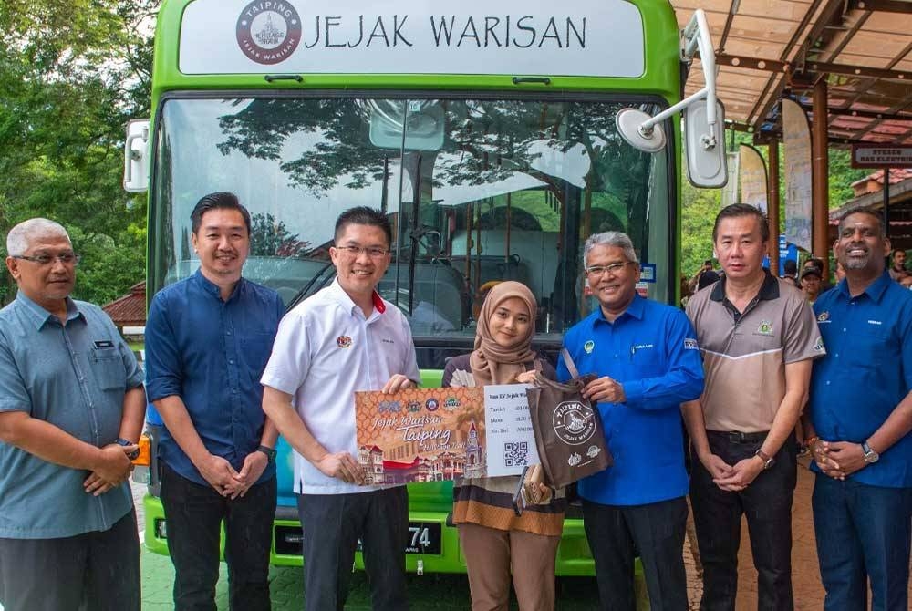 Kah Woh (tiga dari kiri) menyempurnakan gimik Pelancaran Tiket EV Bas MPT bersama Khairul Amir (tiga dari kanan) di hadapan Zoo Taiping & Night Safari pada Selasa. - Foto: MAJLIS PERBANDARAN TAIPING