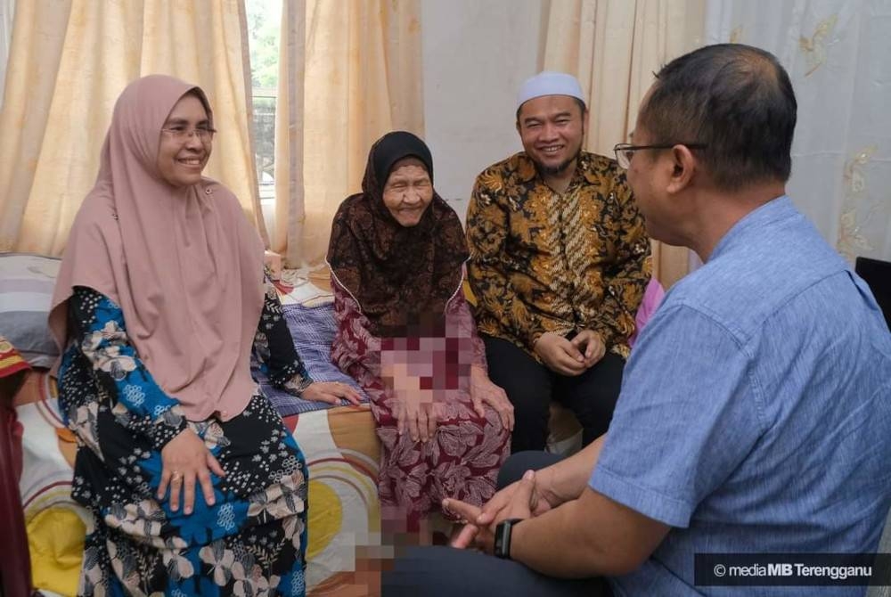 Ahmad Samsuri (kanan) bersama Tuan Faezah meluangkan masa menziarahi Mek Wook di kediaman warga emas itu di Kampung Pulau Panjang di Jertih, Besut. - Foto Ihsan Media MB Terengganu