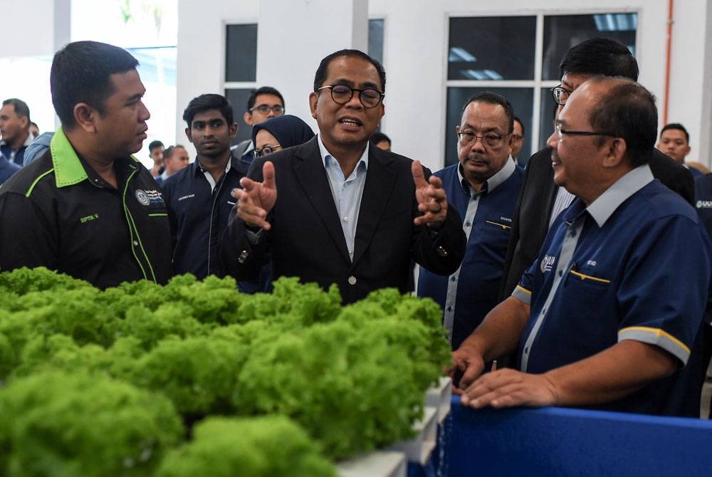 Mohamed Khaled berbincang sesuatu bersama Naib Canselor UUM, Prof Dr Mohd Fo&#039;ad Sakdan (kanan) ketika melawat reruai selepas mengadakan lawatan kerja di UUM, Sintok hari ini. - Foto Bernama