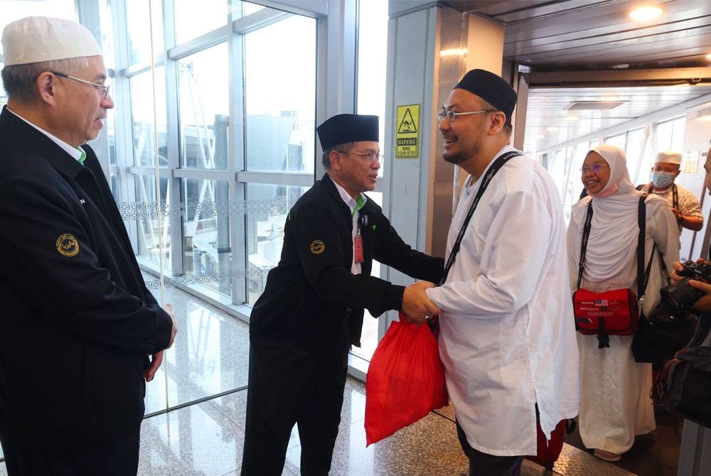 Mohd Na&#039;im (dua dari kiri) bersalaman dengan jemaah haji pada Majlis Sambutan Ketibaan penerbangan akhir jemaah haji Malaysia dari Tanah Suci di KLIA Terminal 1, hari ini. - Foto Bernama