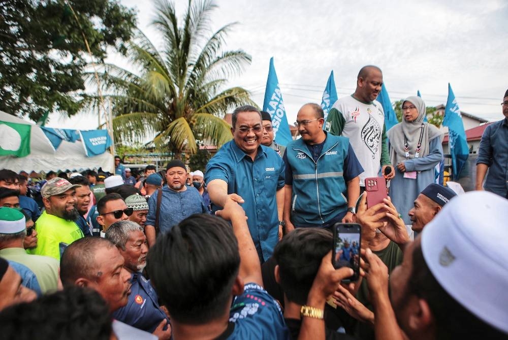 Muhammad Sanusi (kiri) bersalaman dengan orang ramai yang hadir ke program sembang santai sempena kempen PRN di Taman Sri Putra Kuala Kedah pada Selasa.