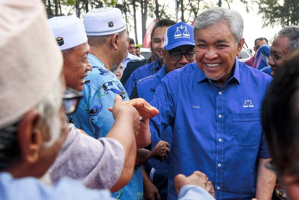 Ahmad Zahid merangkap Pengerusi BN bersalaman bersama orang ramai ketika hadir berkempen untuk calon N.31 Bagan Pinang Mohd Najib Mohd Isa di Jalan Pantai, hari ini. - Foto Bernama