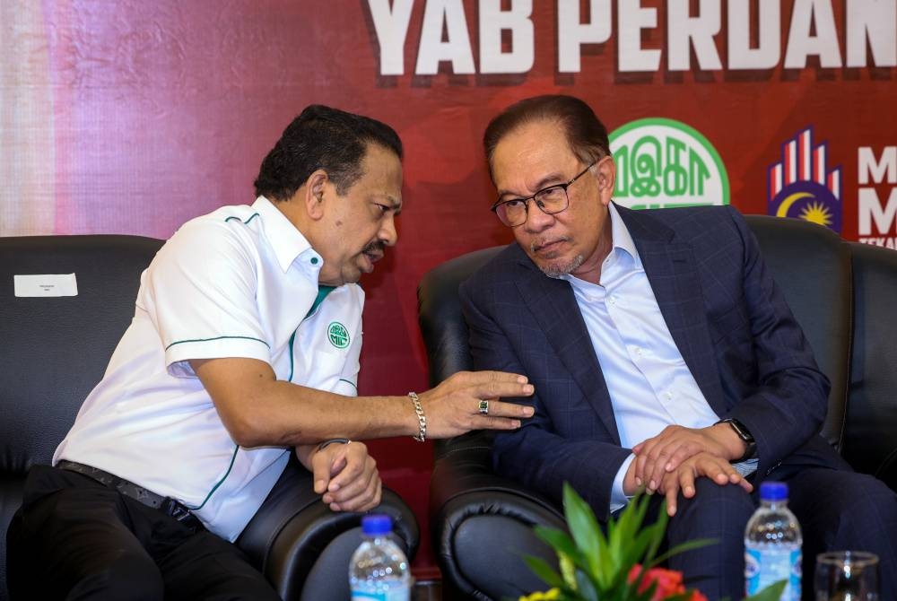 Anwar berbincang dengan Vigneswaran (kiri) ketika hadir pada Majlis perjumpaan khas bersama ahli parti MIC di Ibu Pejabat MIC hari ini. - Foto Bernama