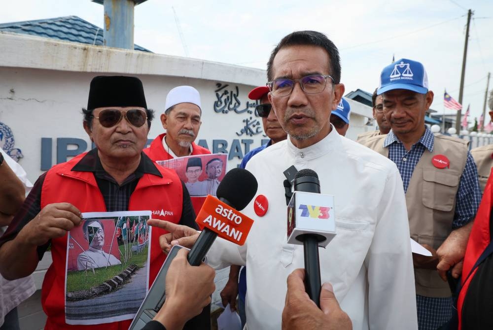 Azan (dua dari kanan) pada sidang media selepas membuat laporan polis berhubung perbuatan khianat pihak tidak bertanggungjawab terhadap bahan kempen beliau di Ibu Pejabat Polis Daerah Kuala Terengganu hari ini. - Foto Bernama