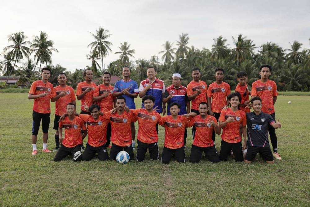 Black (lima dari kiri) dan Rizam (enam dari kanan) bersama pasukan bola sepak di Kampung Dato' Hormat, Sungai Air Tawar pada Rabu.