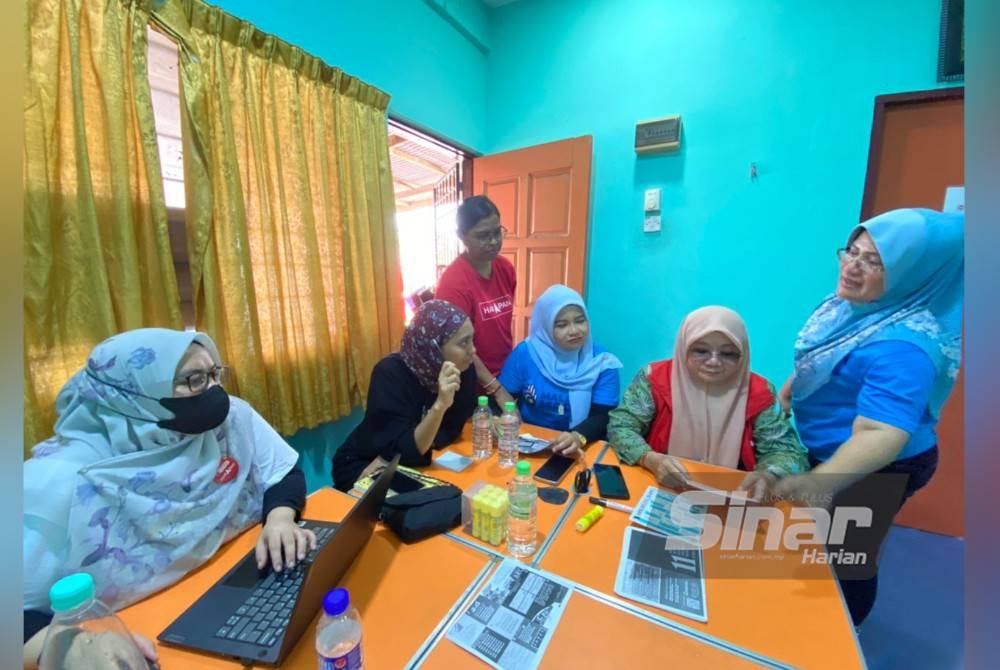 Eka (dua dari kanan) berbincang perjalanan kempen di Bilik Gerakan Calon PH-BN di Taman Perumahan Batu Hampar pada Jumaat.