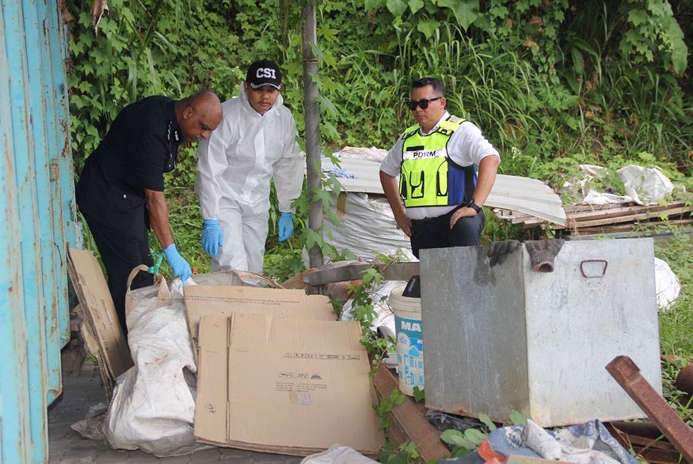 Anbalagan (kiri) memeriksa lokasi mayat yang ditemui dalam guni dipercayai dibunuh, sebelum ditinggalkan di tapak besi buruk Taman Bukit Serdang pada Jumaat.