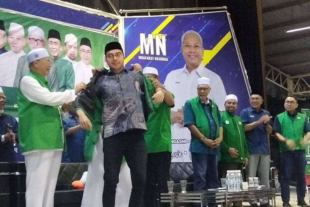 Annuar Afiq Amani dipakaikan vest Pas oleh Abdul Hadi semasa Ceramah Umum Parlimen Ketereh di Kompleks Yayasan Kemiskinan Kelantan (YKK) Padang Kala pada Jumaat.