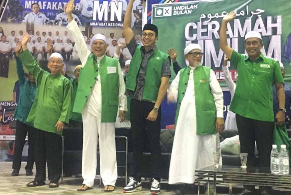 Afiq Amani (tengah) memakai jaket Pas pada Ceramah Umum Parlimen Ketereh di Kompleks Yayasan Kemiskinan Kelantan (YKK), Melor di sini pada Jumaat.