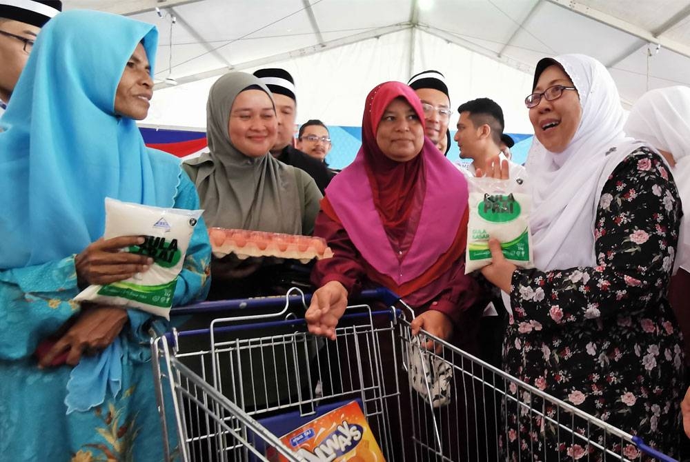 Fuziah (kanan) bertemu pengunjung program Jelajah Jualan Rahmah di Tapak Pasar Malam Tok Adis, di Kuala Terengganu, pada Sabtu.