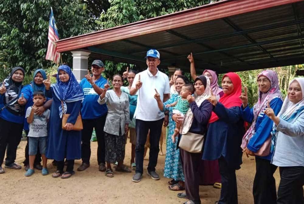 Saiful Yazan (tujuh kanan) bersama jentera BN ketika menyantuni masyarakat Orang Asli.