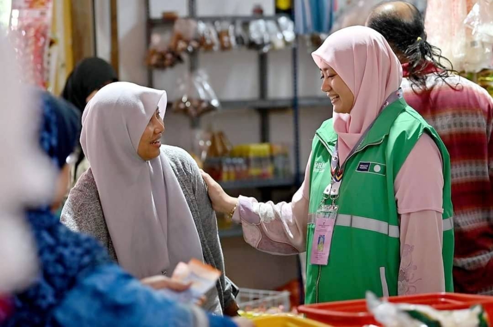 Zuraida (kanan) ketika bertemu peniaga-peniaga dan pengunjung Pasar Bukit Besar dalam program &#039;Hit and Run: Sis turun mengundi&#039; anjuran Pas DUN Ladang.