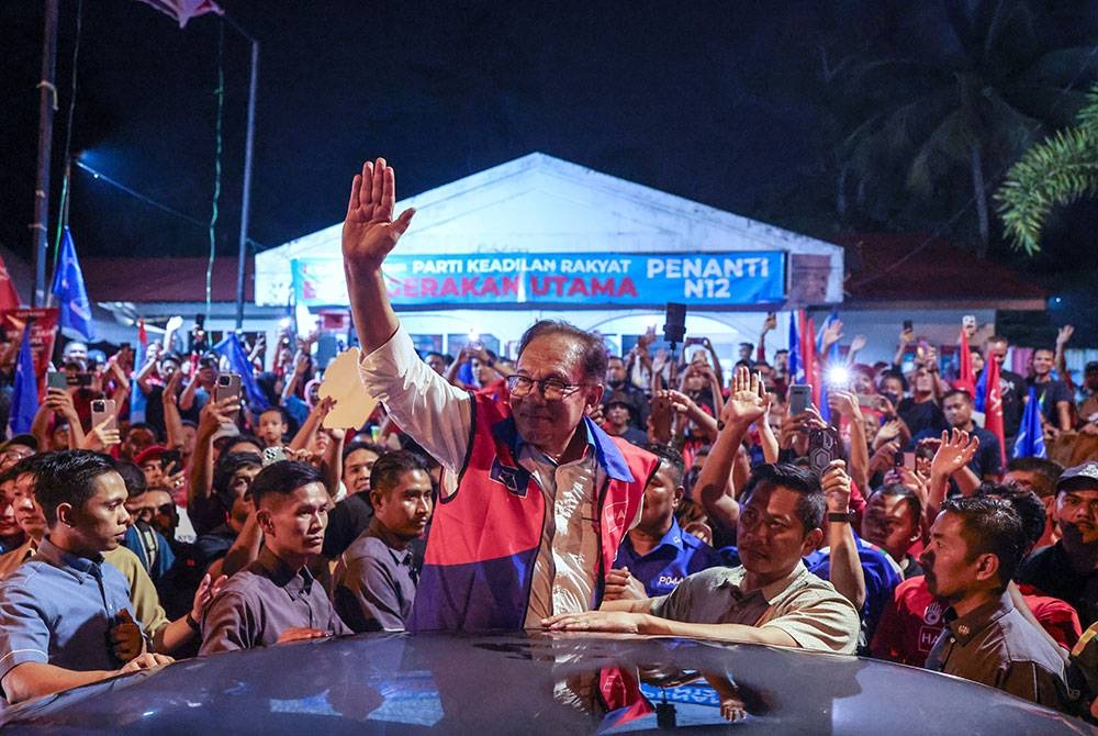 Anwar melambaikan tangan kepada orang ramai pada Ceramah Jelajah Perpaduan Madani di Guar Perahu malam Sabtu. - Foto Bernama