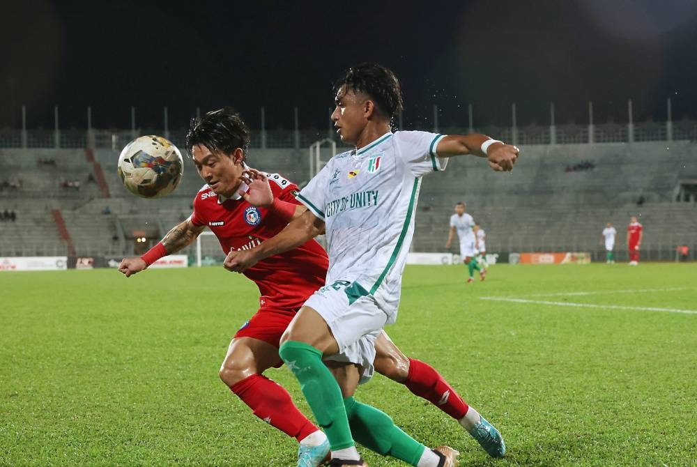 Pemain Sabah, Kwang Min Ko berusaha mengekang tonggak Kuching City, Zahrul Nizwan (kanan) semasa aksi timbal balik pertama Pusingan 16 Piala Malaysia di Stadium Negeri, Kuching pada Sabtu.