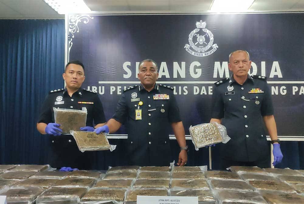 Ketua Jabatan Siasatan Jenayah Narkotik (JSJN) Kedah, Asisten Komisioner Mohd Taufik Maidin (tengah) dan Ketua Polis Daerah Kubang Pasu, Superintenden Rodzi Abu Hassan (kanan) menunjukkan ketulan mampat disyaki ganja yang dirampas.