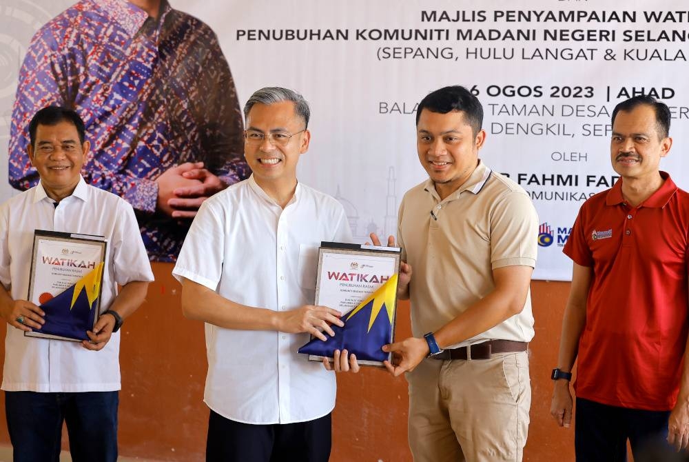 Fahmi (dua dari kiri) menyampaikan Watikah Komuniti Madani kepada Mohamad Firdaous Mohamad Arif (dua dari kanan) pada Program Merdeka@Komuniti DUN Dengkil dan Majlis Penyampaian Watikah Komuniti Madani Peringkat Zon Selatan Negeri Selangor Tahun 2023 di Jenderam pada Ahad. - Foto Bernama