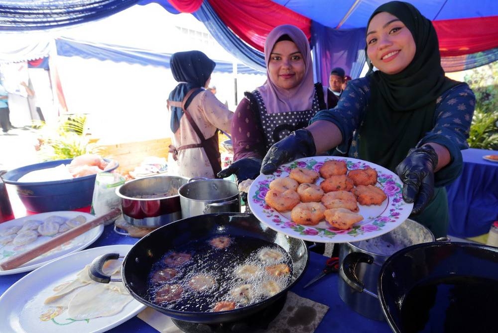 Siti Badriah Abdullah dan rakannya Sharifah Abu Bakar, menunjukkan kuih vadai yang dimasaknya. - Foto Kelab Media Johor