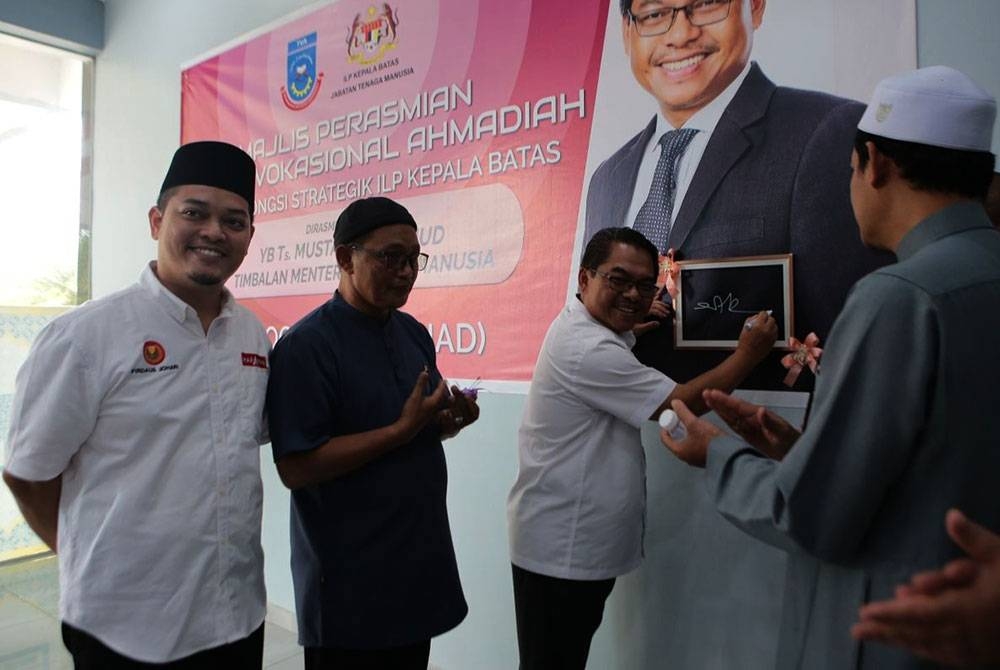 Mustapha melakukan gimik perasmian Tahfiz Vokasional Ahmadiah sambil disaksikan Mohammed Firdaus (kiri) pada Ahad.