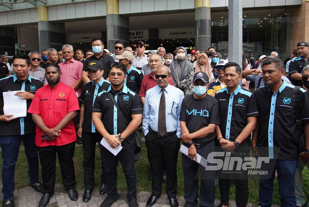 Hishamuddin (depan, empat dari kiri) bersama sekumpulan mangsa penipuan pelaburan saham di hadapan Ibu Pejabat JSJK di Kuala Lumpur pada Isnin.