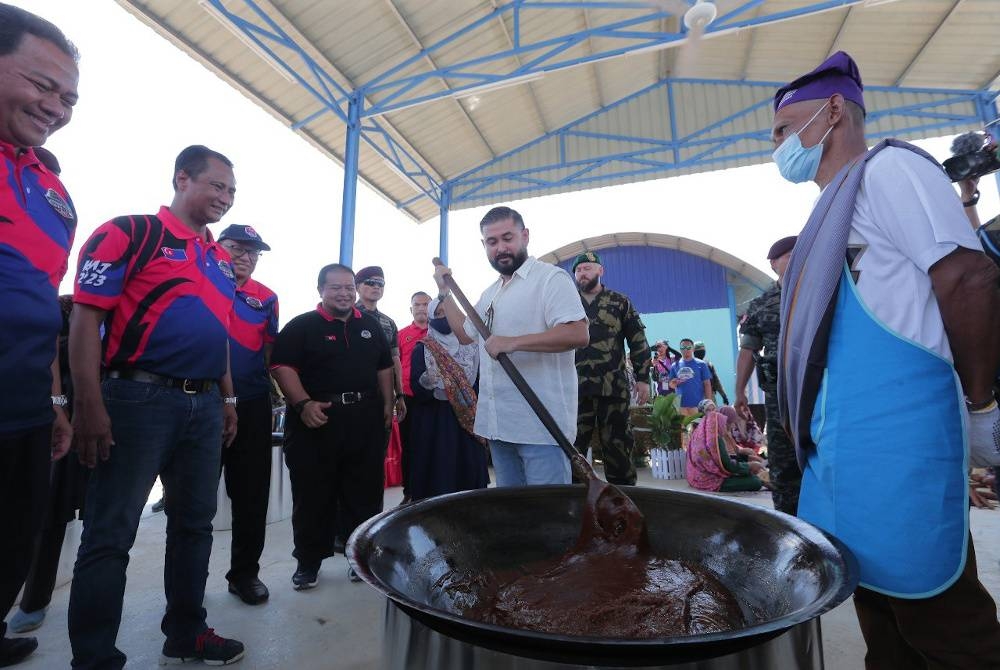 Tunku Ismail berkenan mengacau dodol di Pusat Pertanian Parit Botak. - Foto Kelab Media Johor