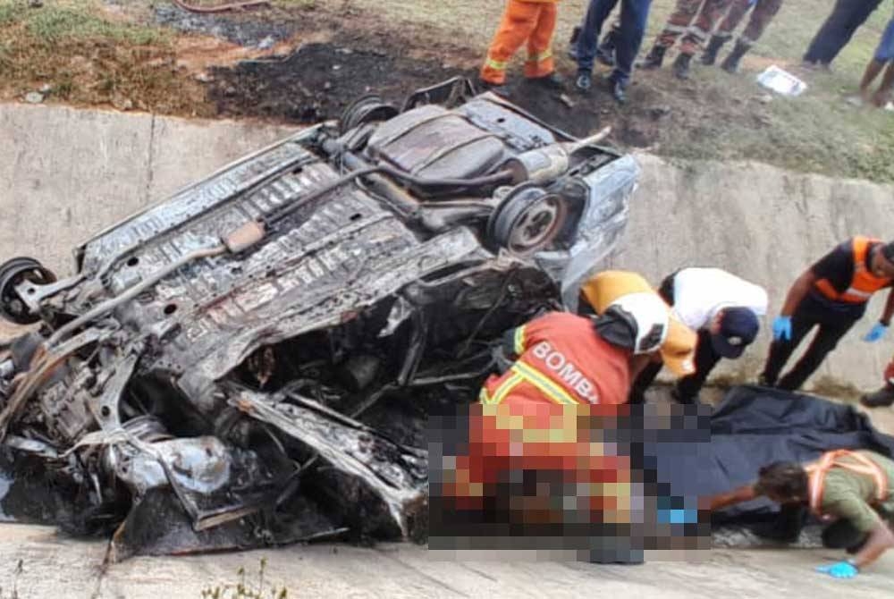 Anggota bomba menjalankan operasi mengeluarkan mangsa daripada kenderaan yang terbakar. - Foto Bomba Perak