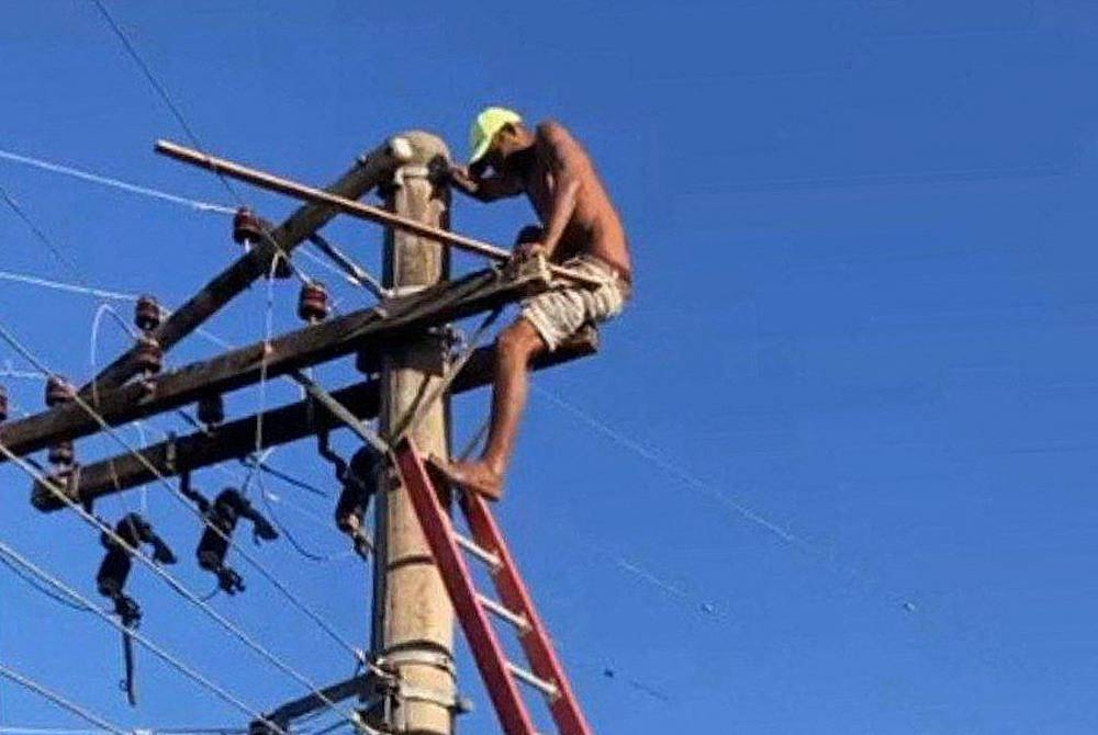 Lelaki itu memanjat dari bumbung rumahnya dan kekal berada di tiang elektrik itu selama 24 jam. - Foto AFP