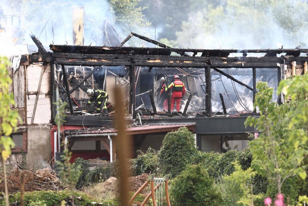 Anggota bomba memeriksa bangunan yang terbakar selepas kebakaran meletus di rumah percutian OKU di Wintzenheim, timur Perancis pada Rabu. - Foto AFP