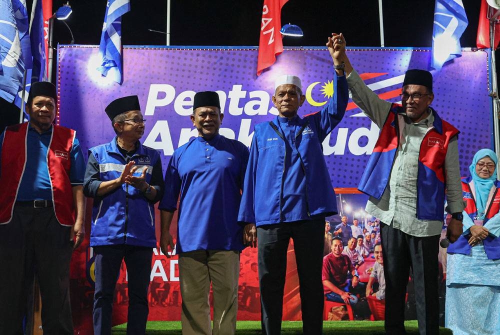 Anwar (kanan) bergambar bersama calon Barisan Nasional (BN) DUN Pengkalan Berangan, Datuk Nik Dir Nik Wan Ku (dua dari kanan) pada program Ceramah Mega Jelajah Perpaduan Madani Terengganu di Wakaf Tapai malam Rabu. - Foto: Bernama