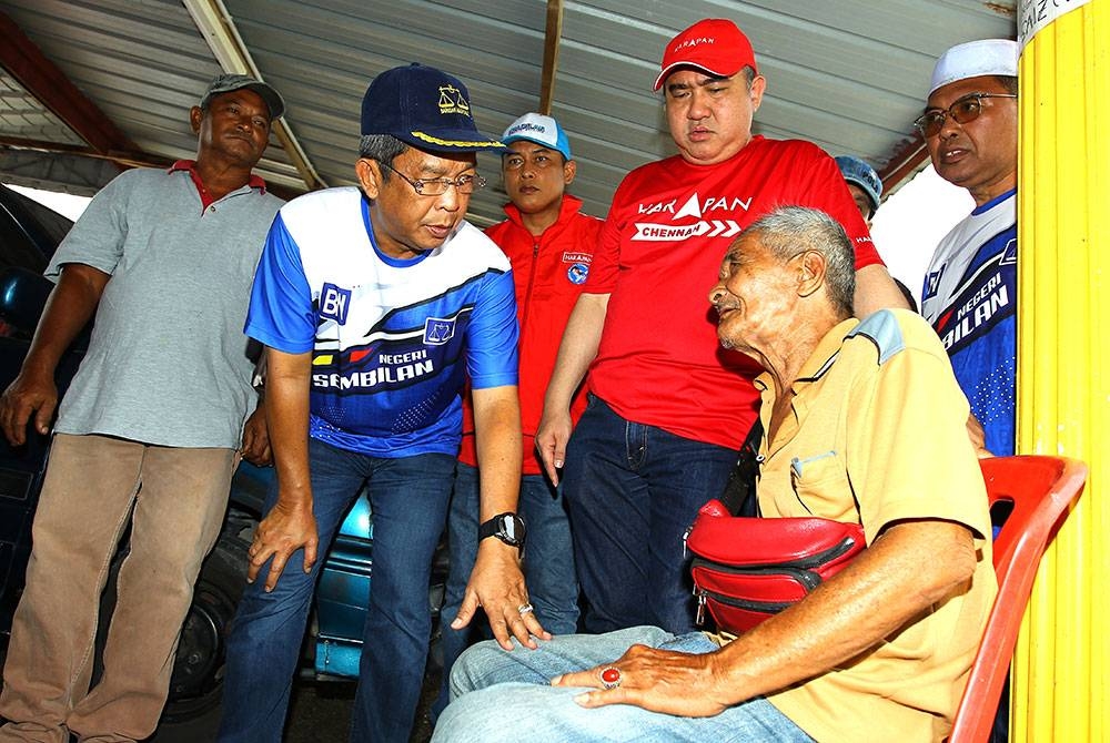 Jalaluddin (dua dari kiri) dan Anthony (dua dari kanan) melawat seorang penduduk di Kampung Chennah.