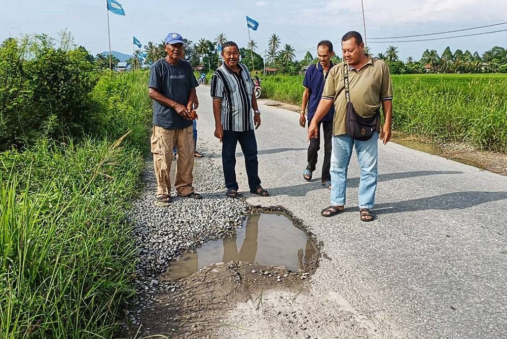 Penduduk kampung menunjukkan Jalan Kampung Pida Tiga Sungai Korok yang rosak dan berlubang.