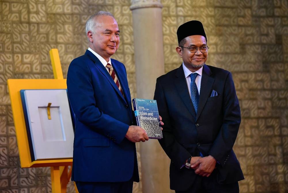 Sultan Perak Sultan Nazrin Shah (kiri) berkenan melancarkan Buku Islam and Biomedicine bersama penulis buku, Datuk Dr Afifi Al-Akiti (kanan) di Institut Pemikiran dan Tamadun Islam Antarabangsa (ISTAC), UIAM pada Khamis. - Foto Bernama