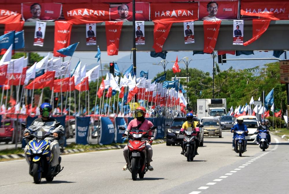 Pengguna jalanraya melalui deretan bendera Pakatan Harapan (PH), Perikatan Nasional (PN) dan Bebas yang dipasang bagi menghangatkan lagi bahang siri kempen Pilihan Raya Negeri (PRN) Dewan Undangan Negeri (DUN) berhampiran bangunan Pusat Transformasi Bandar (UTC) Ampangan. - Foto Bernama