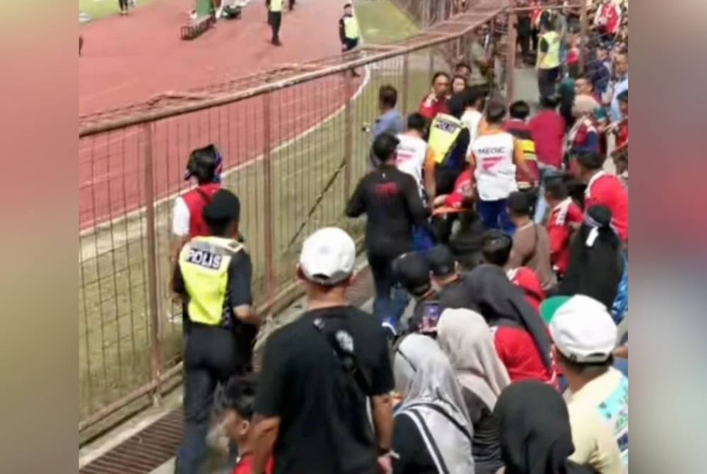 Foto tular menunjukkan polis mengusung mangsa yang rebah ketika menyaksikan perlawanan Liga Super antara Sabah FC dan Johor Darul Ta'Tazim di Stadium Likas, Kota Kinabalu.