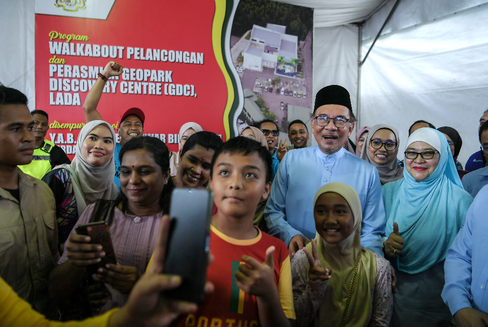 Anwar beramah mesra dengan pengunjung pada program tinjauan mesra pelancongan dan perasmian Geopark Discovery Centre pada Jumaat. - Foto Bernama