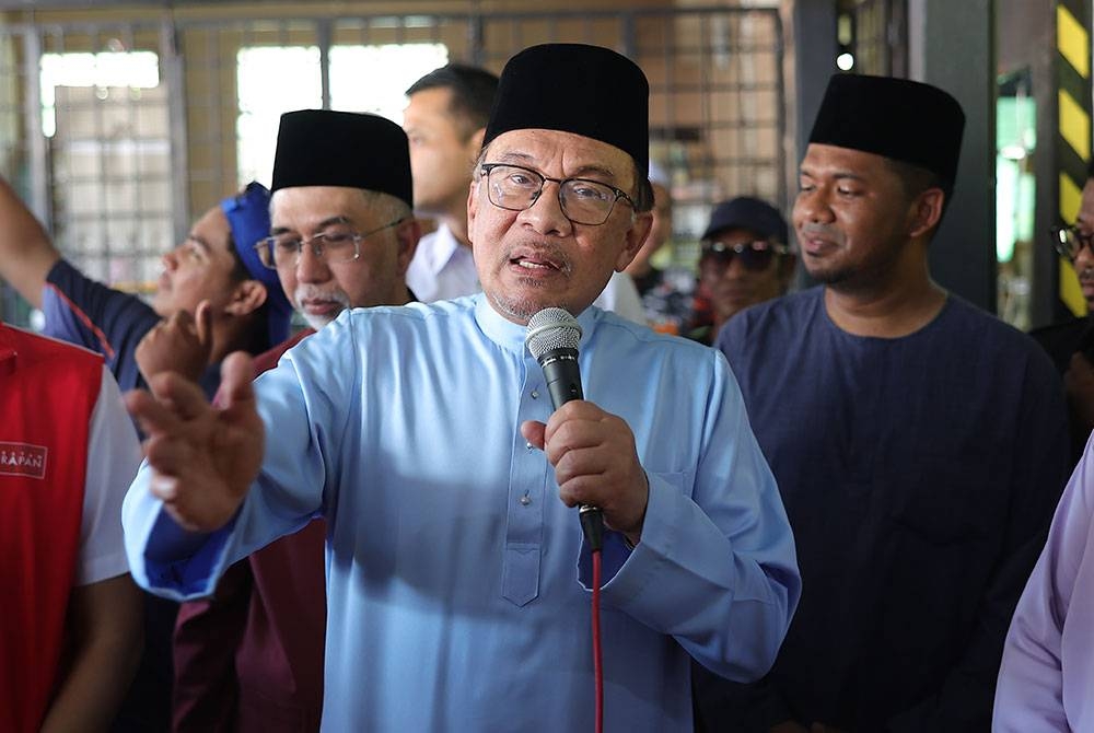 Anwar berucap di Gulai Kalut Hot Stall sebelum menunaikan solat Jumaat di Masjid Qaryah Kampung Perlis pada Jumaat. - Foto Bernama