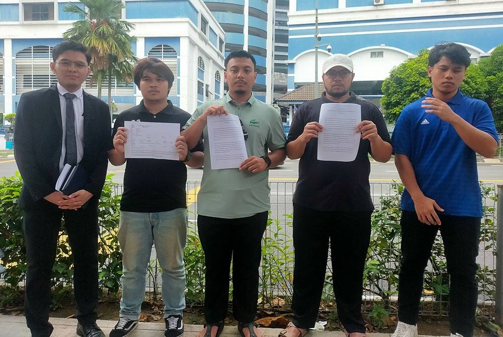 Uzair (tengah) bersama rakan setugas MKM membuat laporan polis berhubung penyelewengan 1Bestari Net di IPD Dang Wangi pada Jumaat.