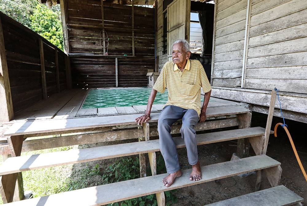 Jusoh duduk di tangga rumah yang dibina di atas tanah orang lain di Kampung Tiruk, Serada di Kuala Terengganu.