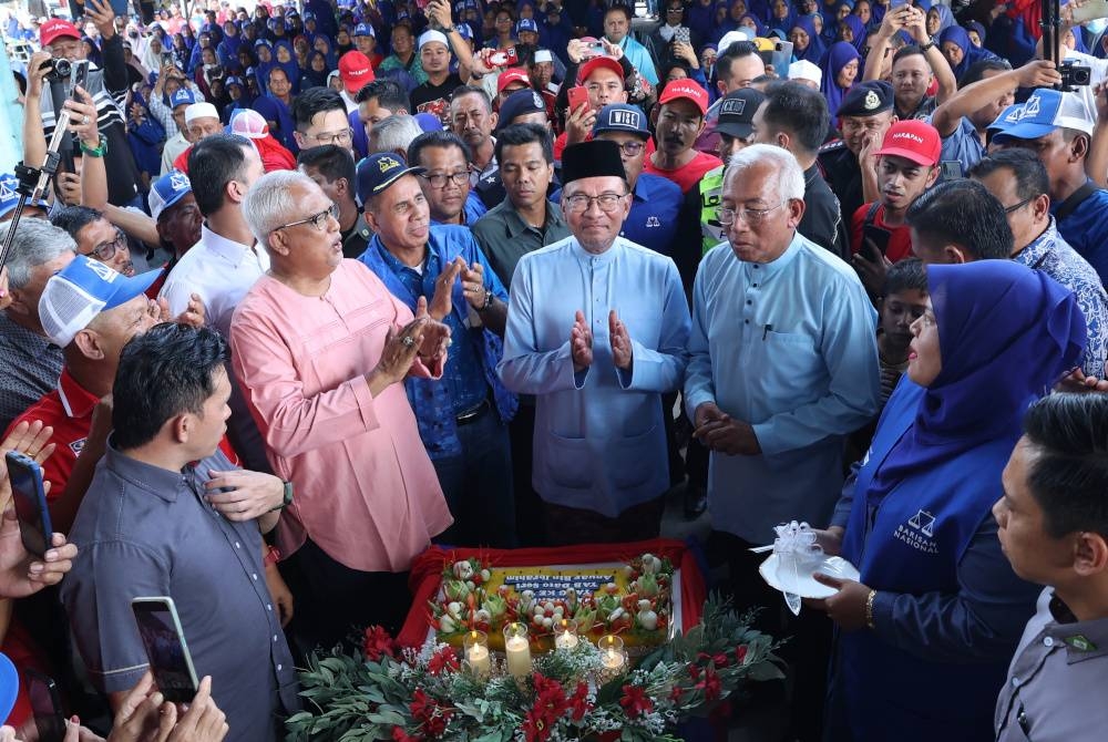 Perdana Menteri Datuk Seri Anwar Ibrahim diraikan dengan acara memotong pulut kuning sempena hari lahir beliau sebaik tiba pada Jelajah Perpaduan Madani di Naka dekat Kuala Nerang. - Foto Bernama