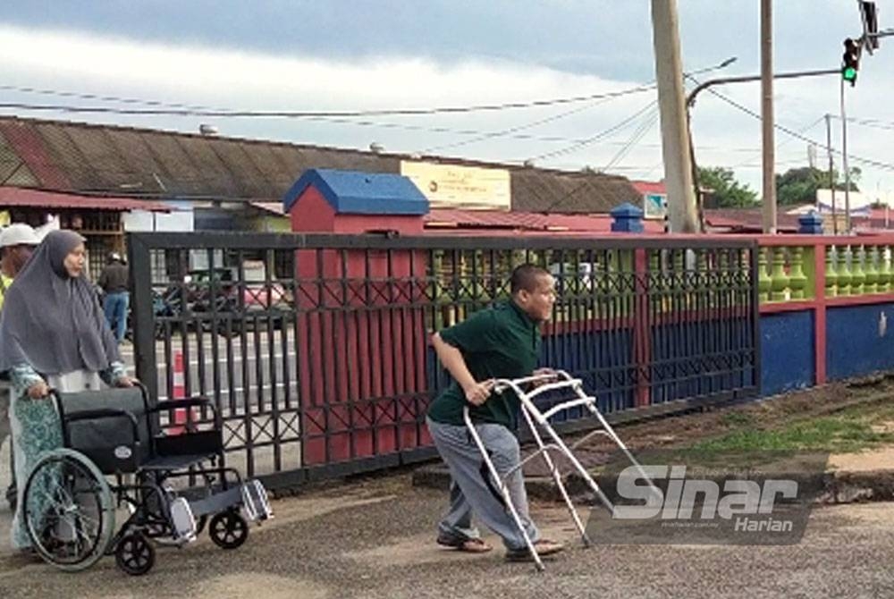 Zikrillah memasuki SK Panji bersama ibunya untuk membuang undi.