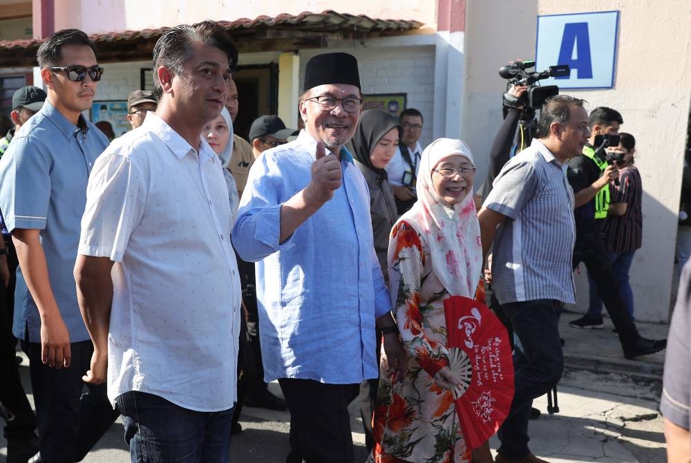 Anwar dan isteri, Datuk Seri Dr Wan Azizah Wan Ismail mengundi bagi DUN Permatang Pasir pada PRN Pulau Pinang di Sekolah Kebangsaan Seri Penanti hari ini. - Foto Bernama