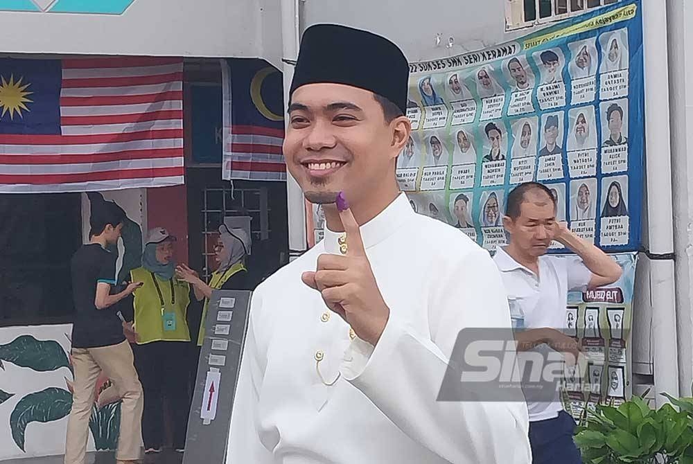 Abdul Qayyim yang lengkap berpakaian baju Melayu hadir mengundi di Sekolah Menengah Kebangsaan Seru Keramat.