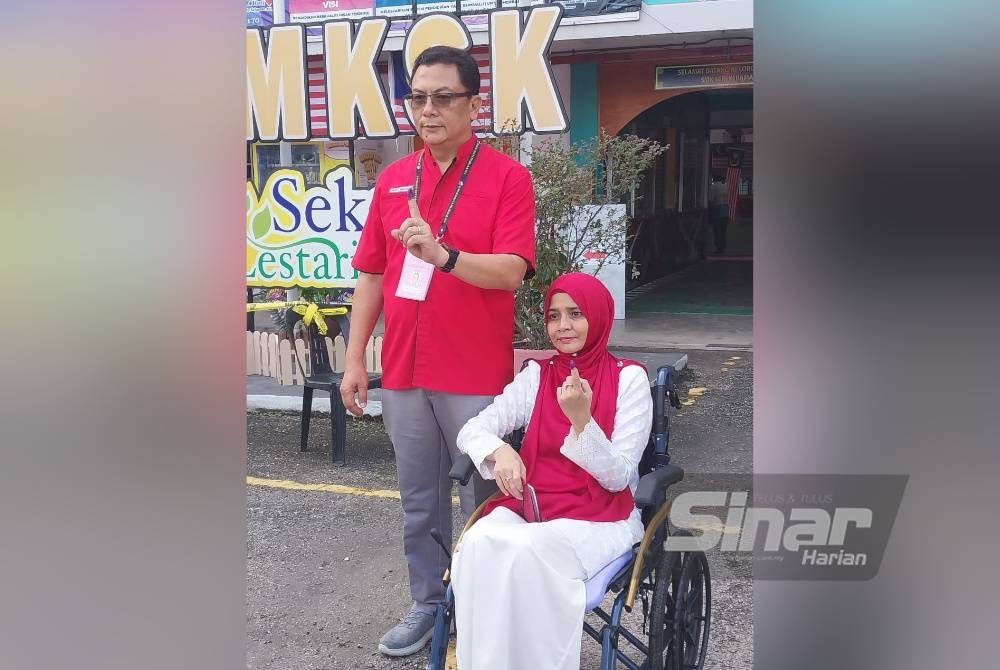 Mohd Kamri (kiri) bersama Suzana hadir ke pusat mengundi di SMK Seri Keramat pada Sabtu.