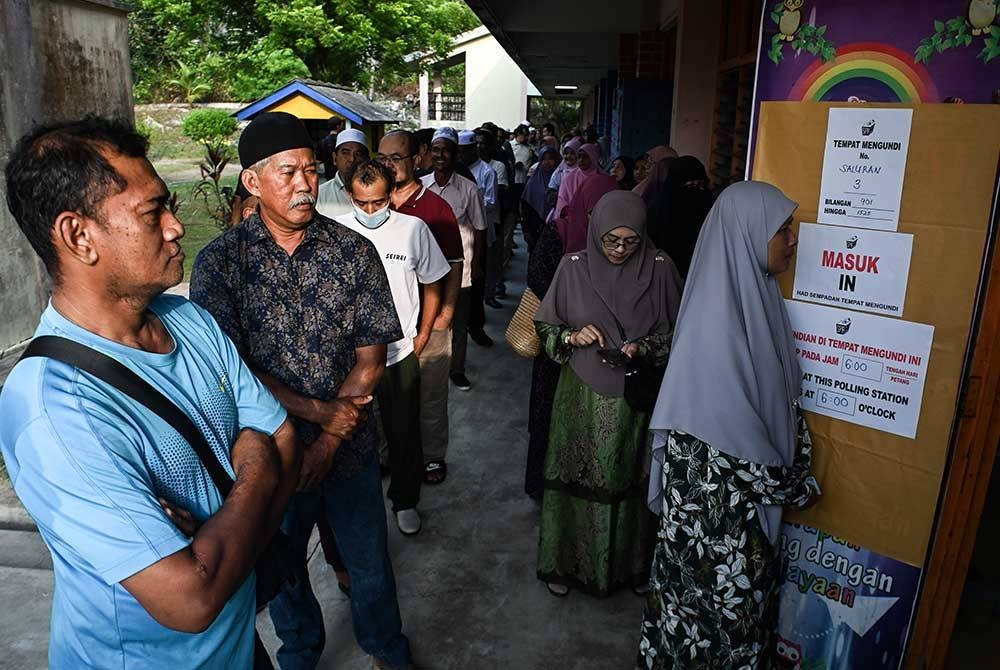 Orang ramai beratur untuk mengundi bagi DUN N.19 Ru Rendang sempena PRN di Pusat Mengundi Sekolah Kebangsaan Rusila pada Sabtu. - Foto: Bernama