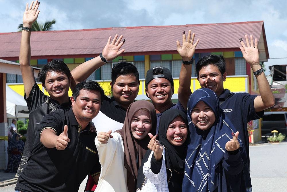 Nor Hafizatulakmal Mohamad Dahalan (kanan) bersama tujuh adik-adiknya Luqman Norhakem, Mohd Redzuan Adzha, Mohd Atiflutfi, Nurul Hakimah, Mohamad Alif Asyraf, Nurul Aqilah dan Mohamad Hakimin ceria selepas menunaikan tanggungjawab mereka sebagai pengundi bagi DUN Anak Bukit pada Sabtu. - Foto: Bernama