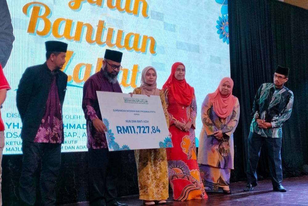 Nur Dini Azih layak menerima bantuan pembiayaan pinjaman PTPTN daripada MUIP pada majlis penyerahan bantuan pendidikan dan pembangunan asnaf miskin di Hotel Grand Makmur pada Sabtu.