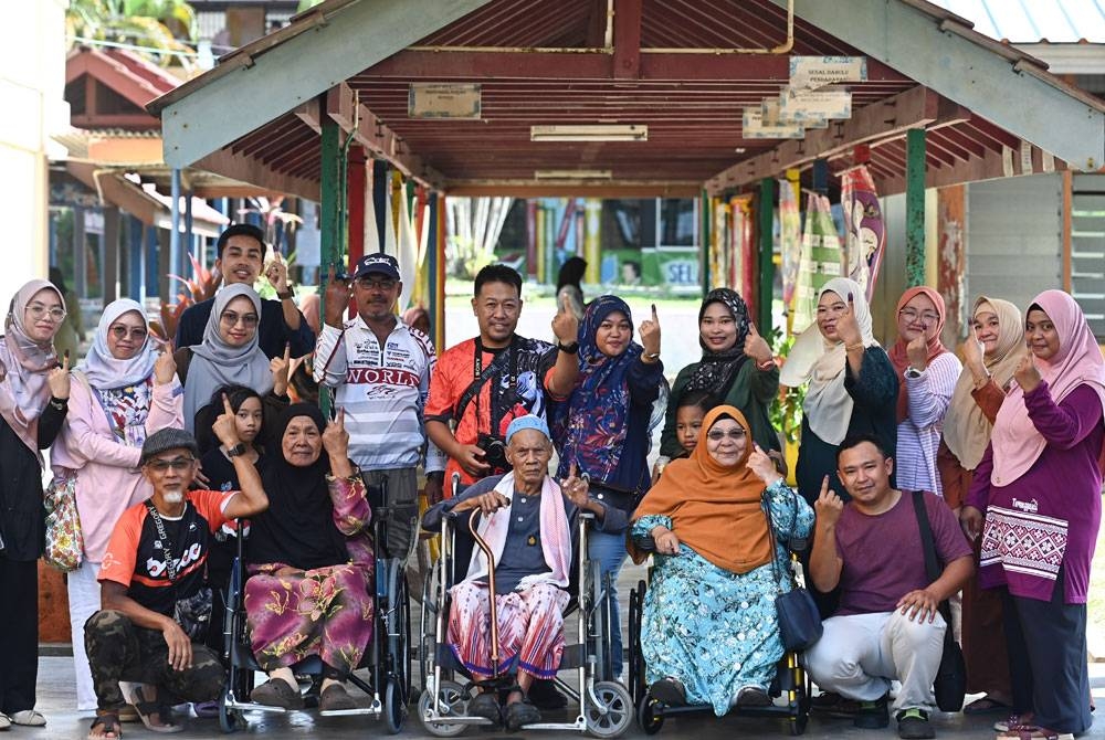 Seramai 17 ahli keluarga yang hadir menunjukkan jari berdakwat selepas mengundi bagi Dewan Undangan Negeri (DUN) Ru Rendang sempena PRN di Pusat Mengundi Sekolah Kebangsaan Rusila hari ini. - Foto Bernama