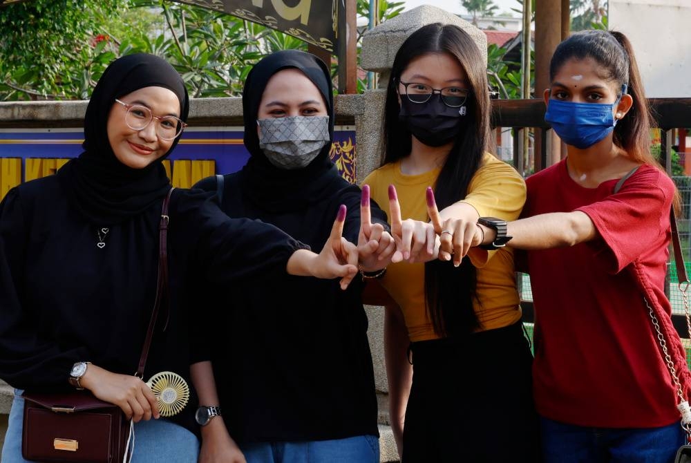 Pengundi (dari dari kiri) Maisara Rozi, 22, Ain Syafiqeen Rauf, 25, Ooi Shi Yun, 21 dan Archana Ilangovan menunjukkan jari yang dicelup dengan dakwat kekal selepas mengundi bagi DUN N.40 Kota Anggerik sempena Pilihan Raya Negeri di Sekolah Kebangsaan Seksyen 7, Shah Alam. - Foto Bernama