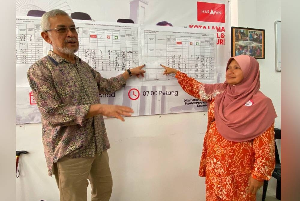 Khalid bersama Dr Hafizdah menunjukkan kawasan yang dimenangangi PH di DUN Kota Lama.