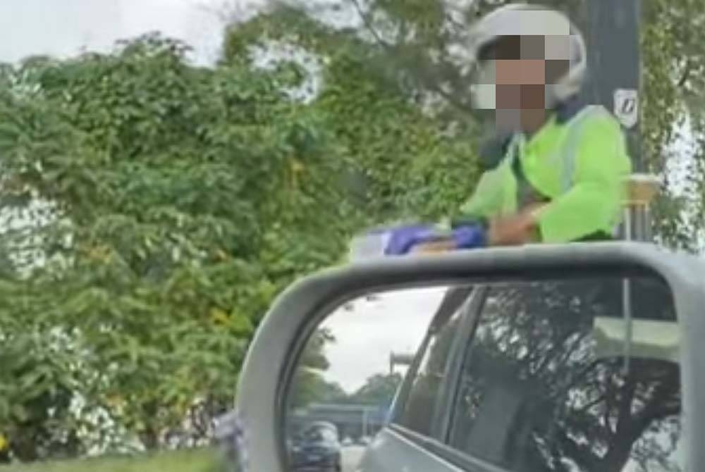 Tangkap layar video tular menunjukkan pekerja pembersihan yang bertindak membuang sampah di Pantai Lido.