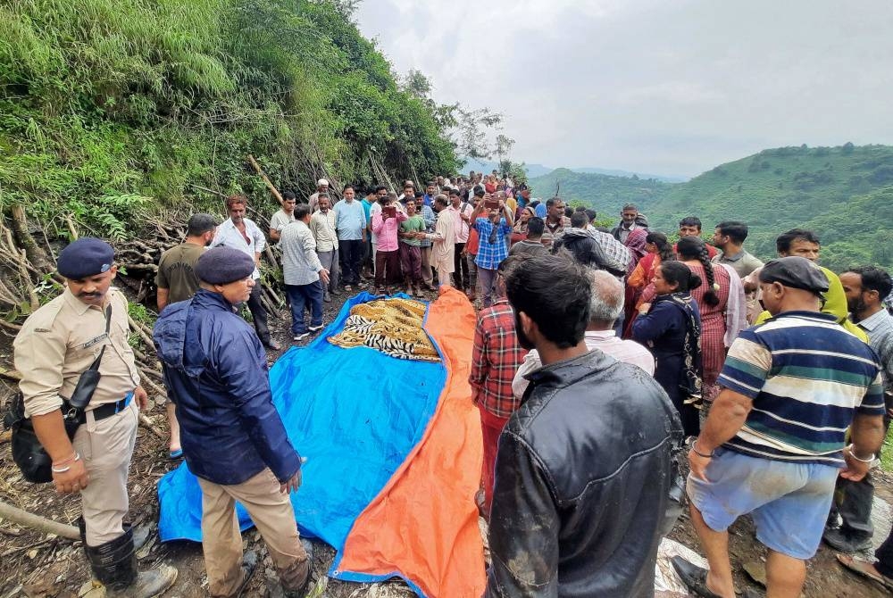 Kakitangan keselamatan dan penduduk kampung berkumpul di sekeliling mayat mangsa yang maut dalam kejadian tanah runtuh selepas hujan lebat di kampung Jadon di daerah Solan di Himachal Pradesh, India pada 14 Ogos 2023. - Foto AFP